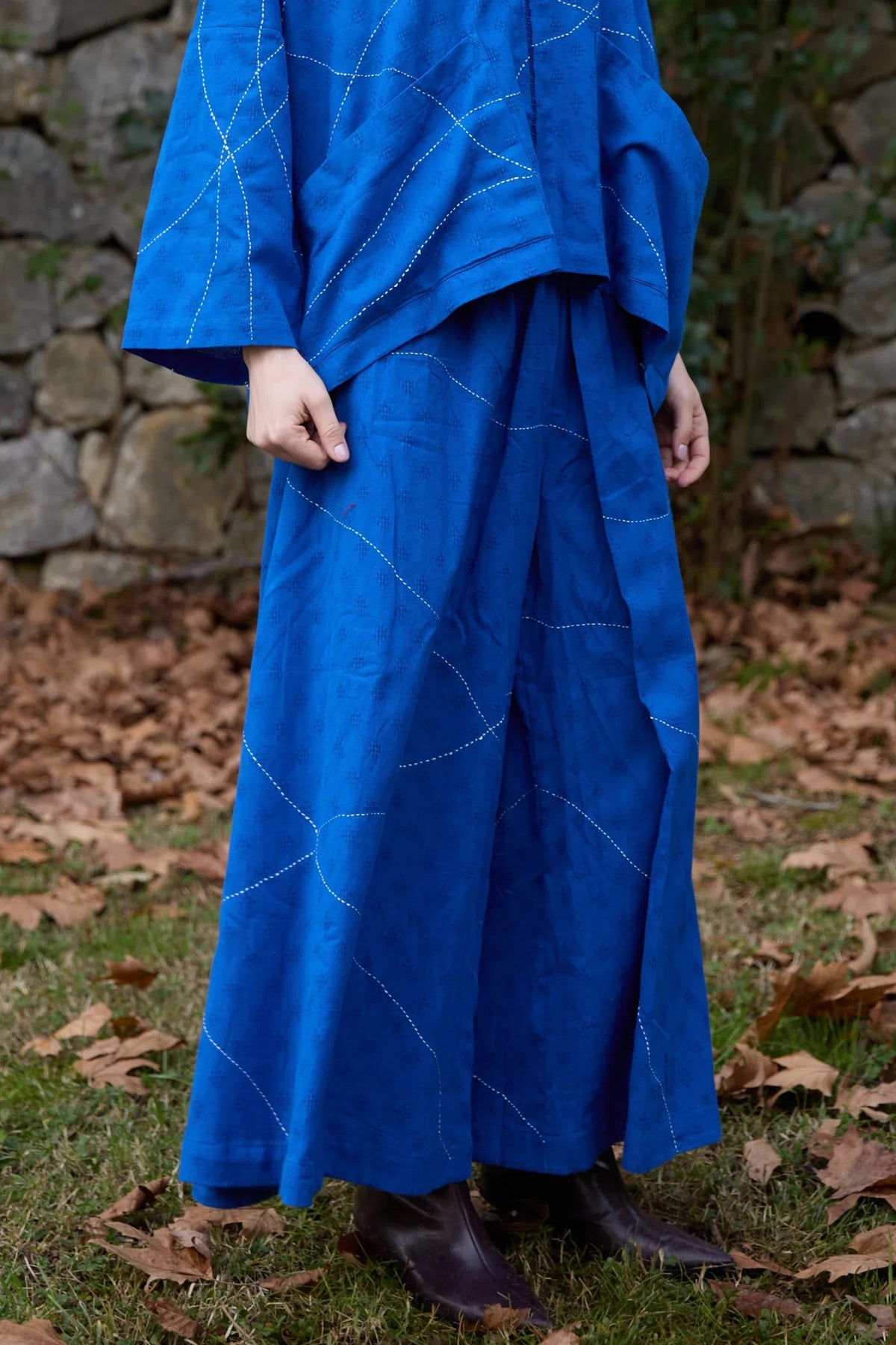 White Canvas Cloud Dahlia Pants in blue handwoven dobby cotton with Kantha stitching, angled view on model