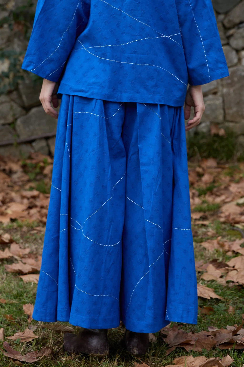 White Canvas Cloud Dahlia Pants in blue handwoven dobby cotton with Kantha stitching, back view on model