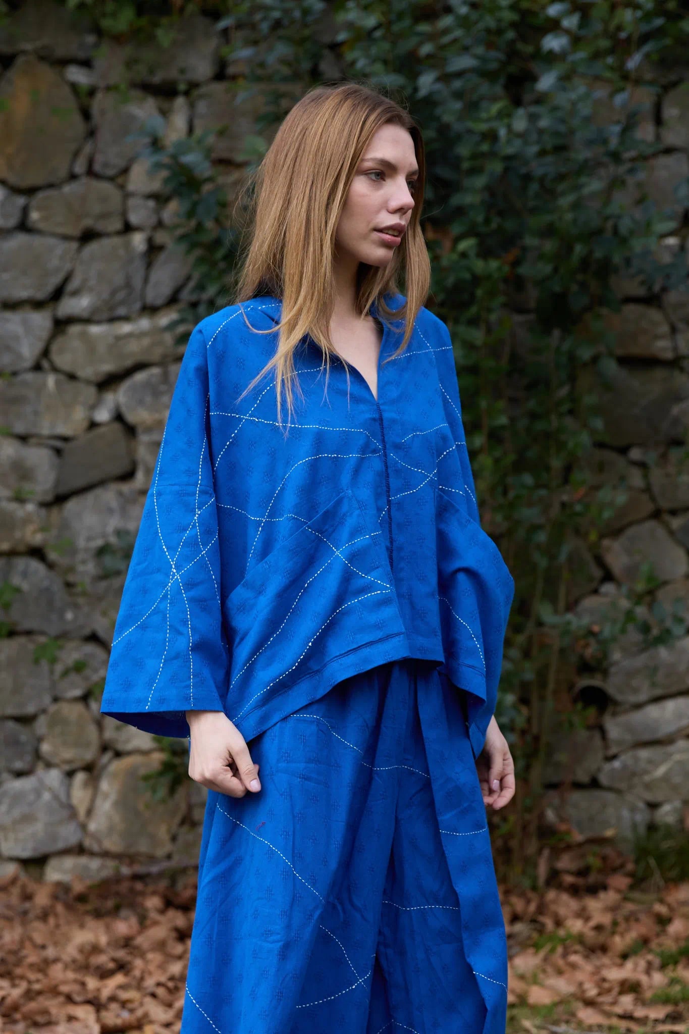 White Canvas Cloud Dahlia Top in blue handwoven dobby cotton with Kantha stitching, angled view on model