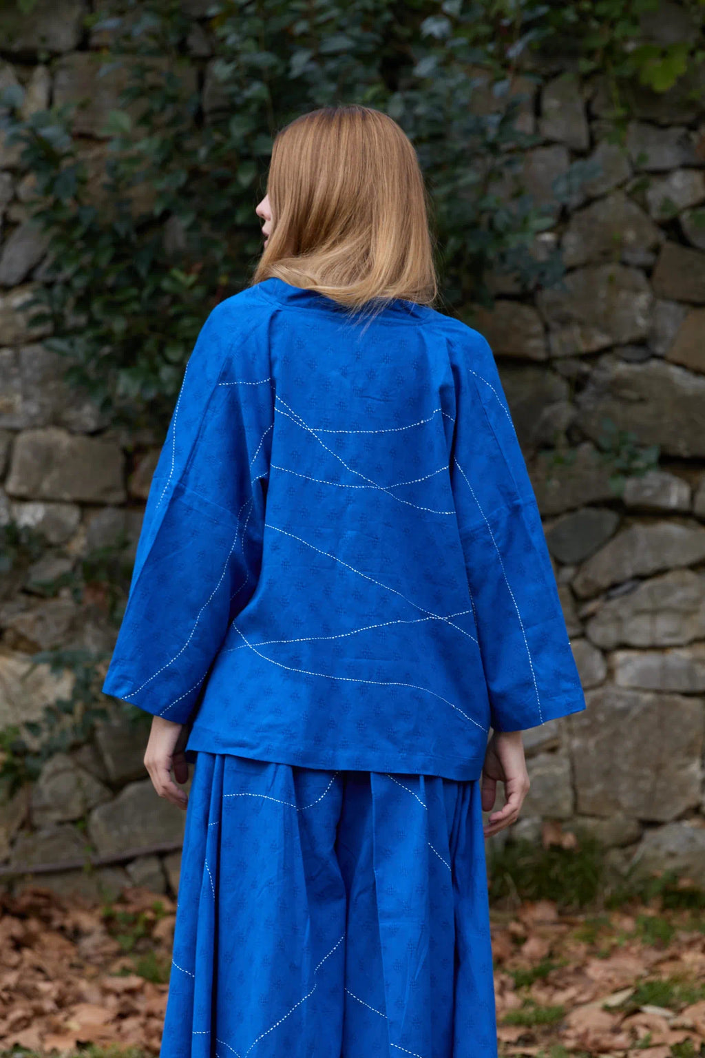 White Canvas Cloud Dahlia Top in blue handwoven dobby cotton with Kantha stitching, back view on model