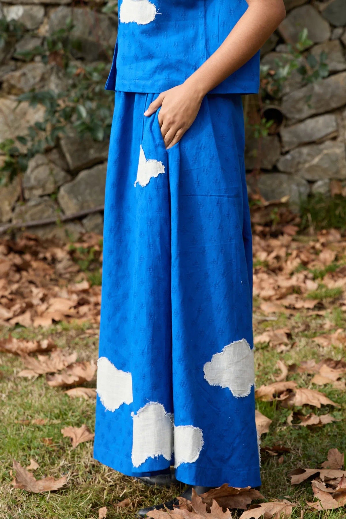 White Canvas Cloud Marti Pants in blue handwoven dobby cotton with applique work, angled view on model