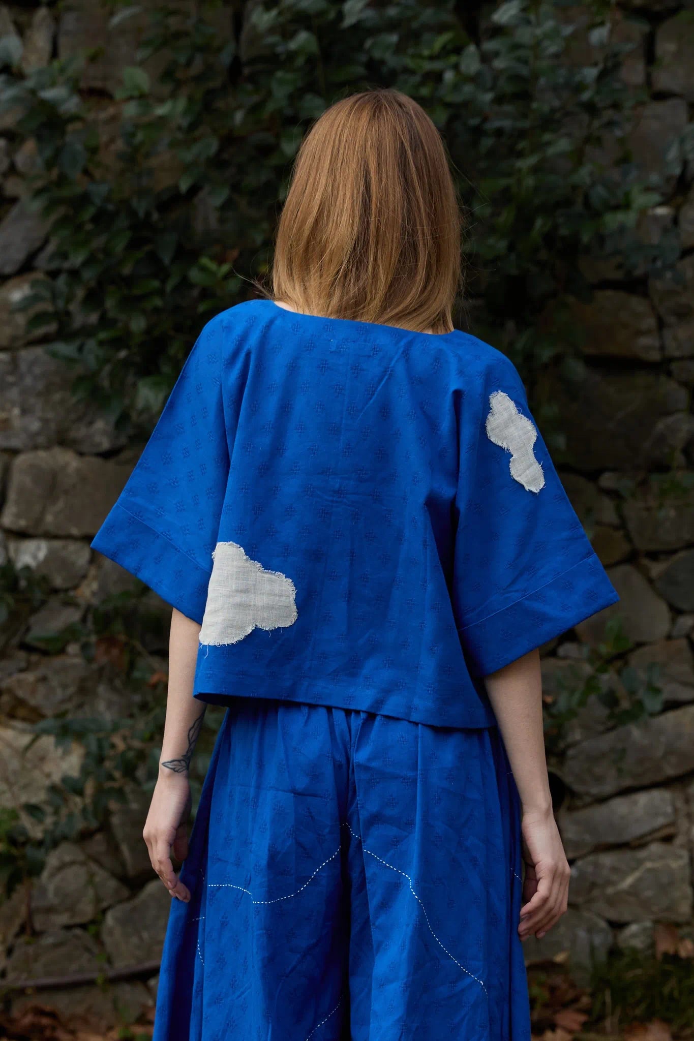 White Canvas Cloud Nikki Top in blue handwoven dobby cotton with applique work, back view on model