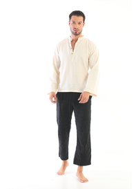 A male model wearing a cream-colored shirt and black pants, standing against a white background.